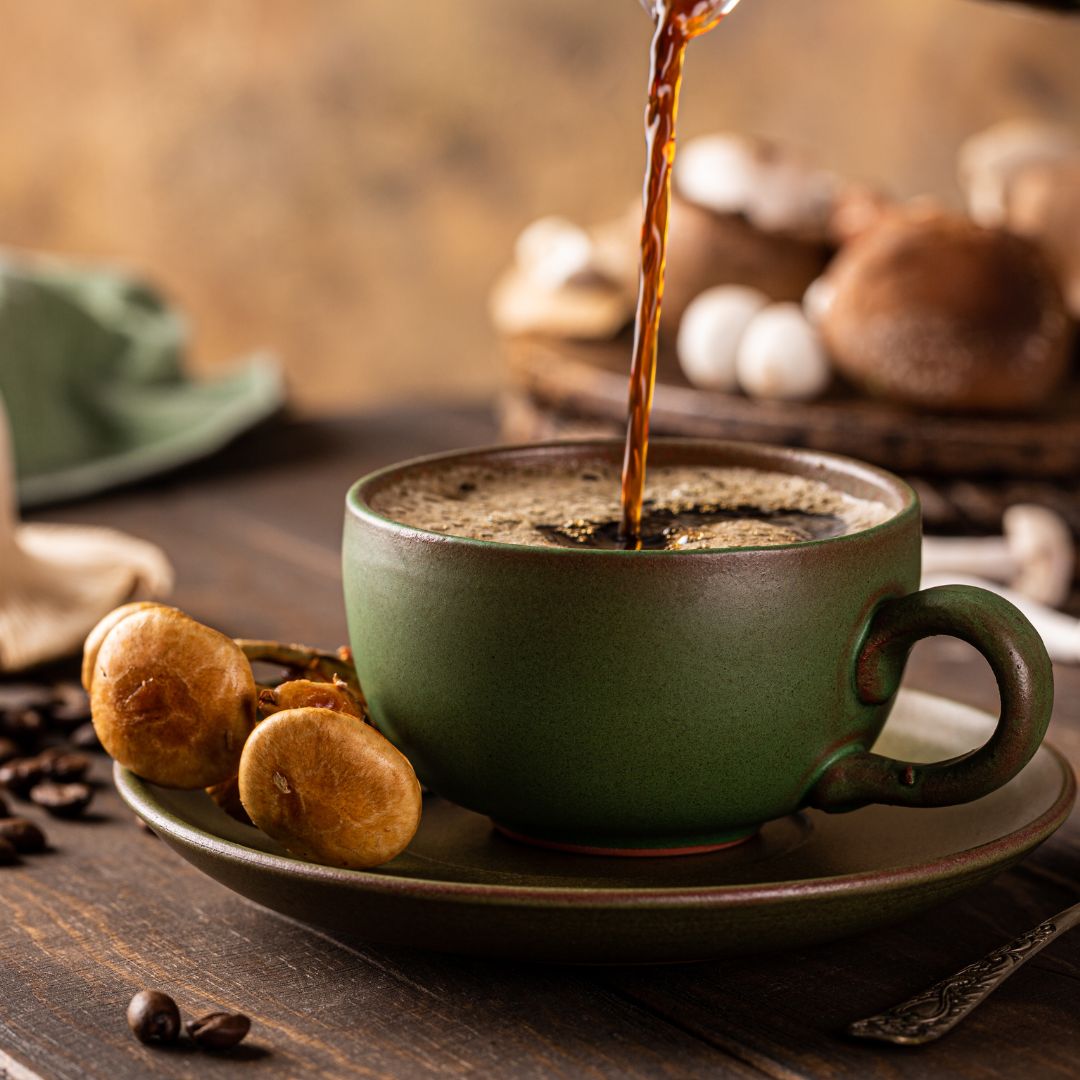 A cup of mushroom coffee being brewed with a coffee maker, with a bag of mushroom powder and a scoop nearby.